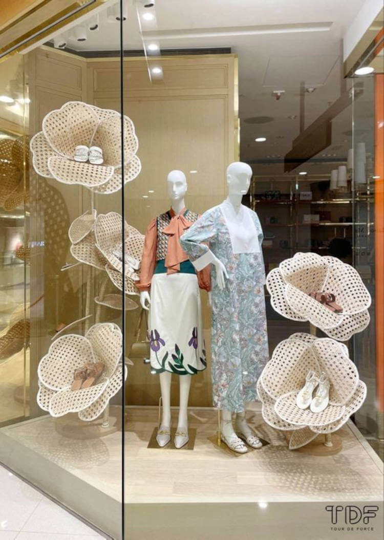 Decoração de vitrine com flores. Loja de sapatos com modelos dentro de flores.