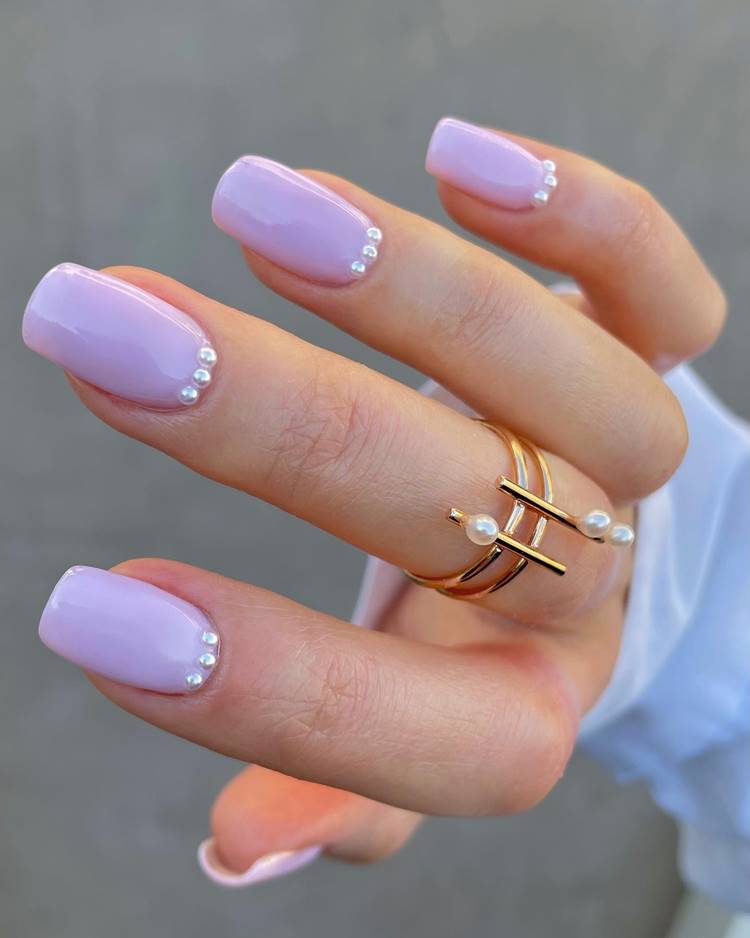 Foto de unhas decoradas com pérolas.