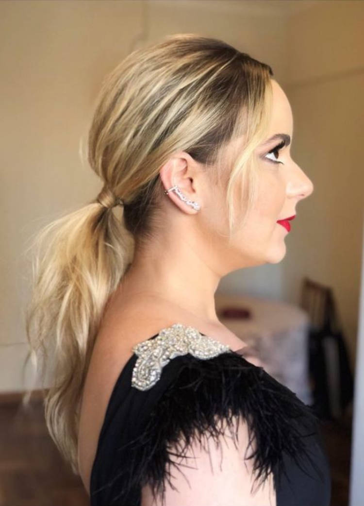 Mulher de pele clara com cabelo loiro em rabo de cavalo baixo