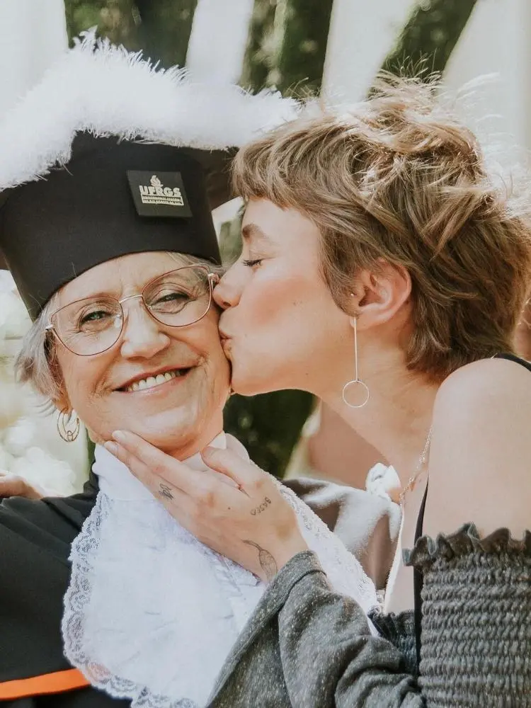 Mari Krüger beijando sua mãe, que está de beca e capelo