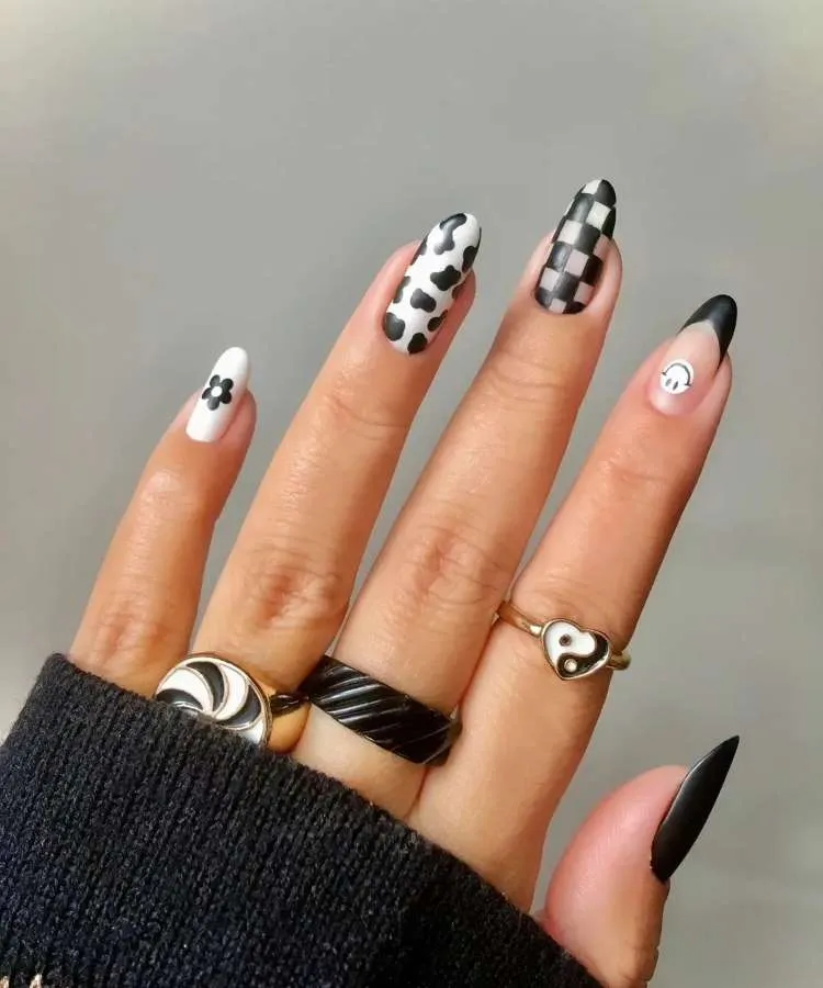 Unha almond decorada nas cores: preto e branco. Desenho de: flor, pinta de vaca, xadrez, emoji sorrindo com francesinha.