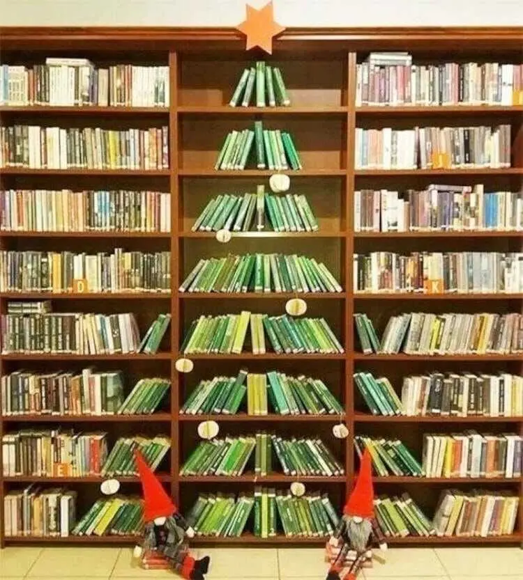 Estante com livros verdes formando árvore de Natal
