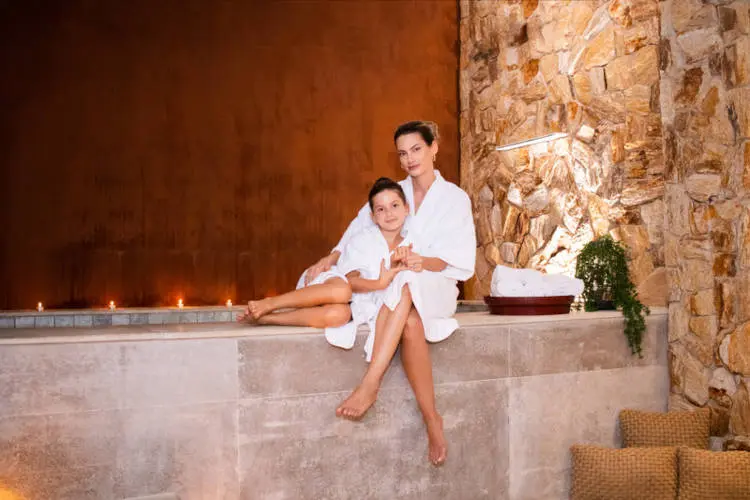 Foto de mulher e filha de roupão brancos em spa
