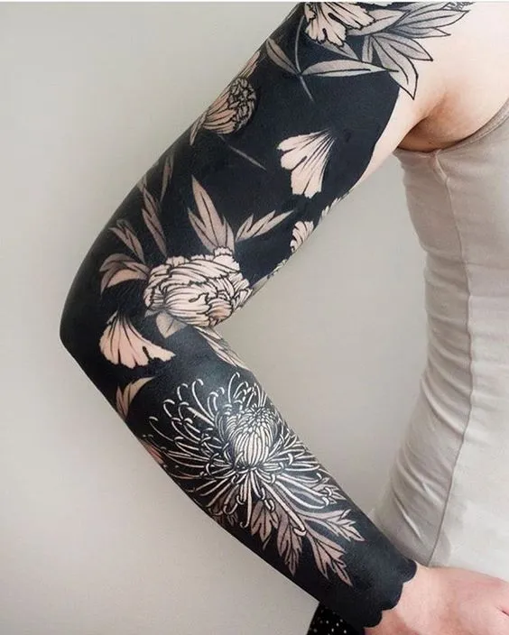 braço fechado com tatuagem botânica preta