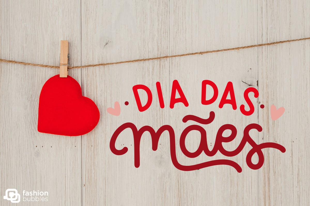 Montagem de fundo de madeira com varal de um coração e frase "Dia das Mães" em vermelho com coração