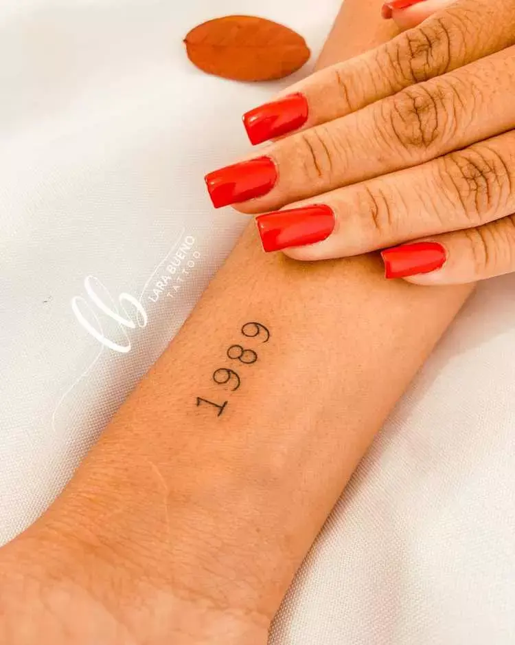 Pessoa de pele clara com tatuagem "1989" no pulso