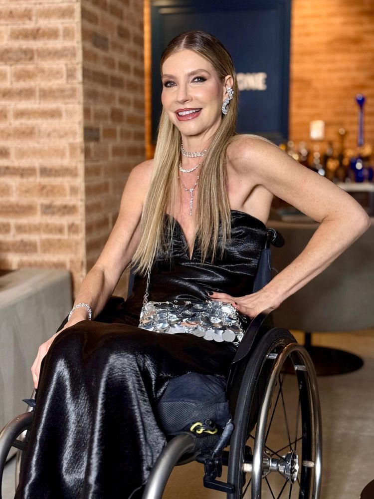Dea Schwarz de vestido sem alça preto e bolsa prata