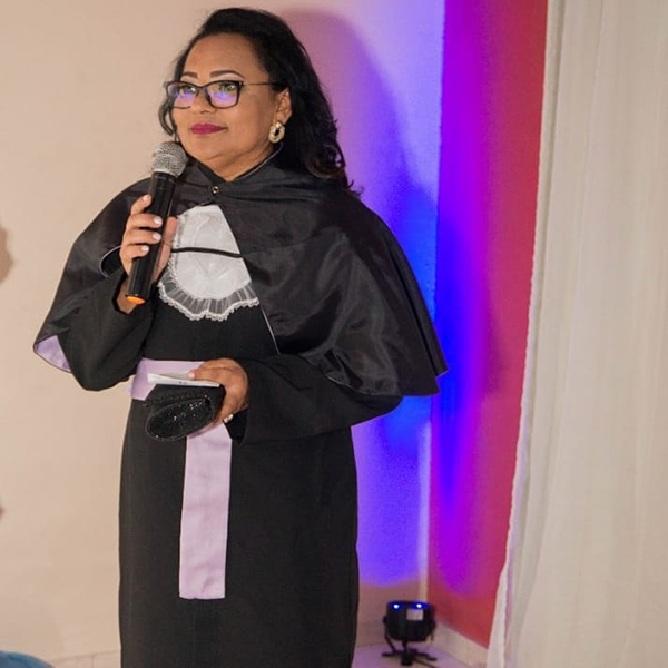 Mara de beca preta segurando microfone
