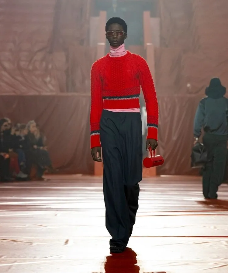 Foto de modelo na passarela usando suéter vermelho, uma das tendências da Semana de Moda de Paris Outono Inverno 2026