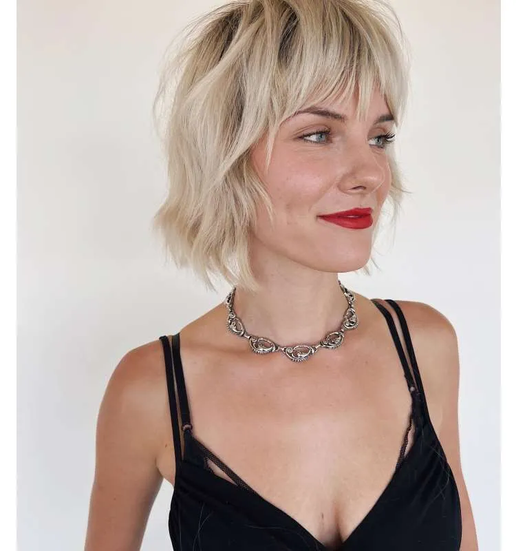 Mulher com cabelo loiro curto e repicado na altura do queixo
