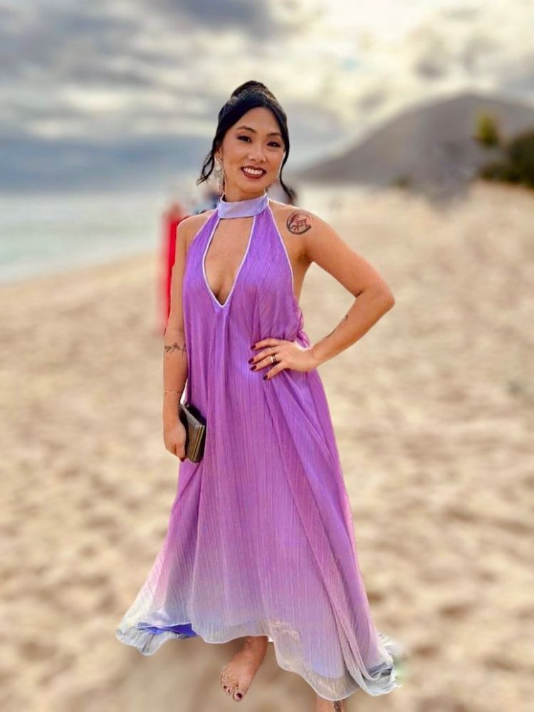 Mulher asiática em casamento na praia usando vestido midi roxo decotado