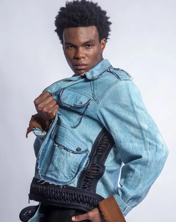 Modelo posando em fundo branco com uma jaqueta jeans de Ronaldo Silvestre 