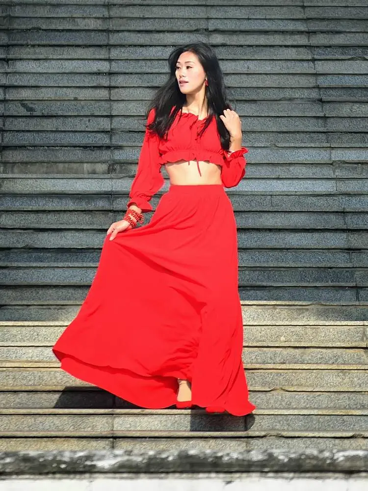 Mulher usa top cropped e saia longa como roupa vermelha para Natal