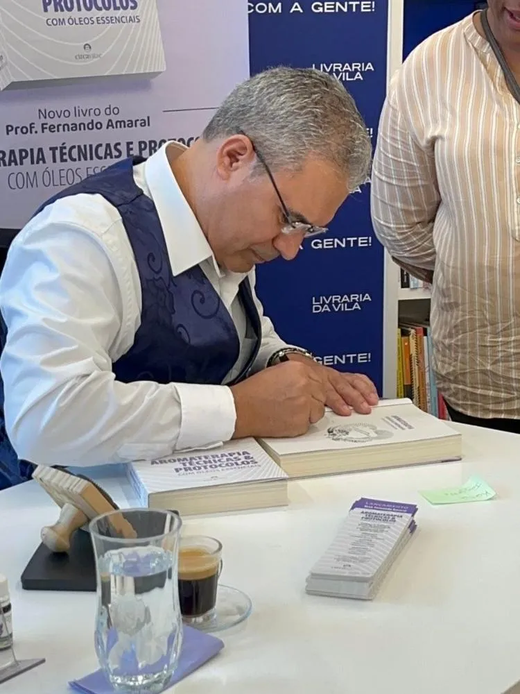 Foto do Professor Fernando Amaral autografando seu novo livro de aromaterapia