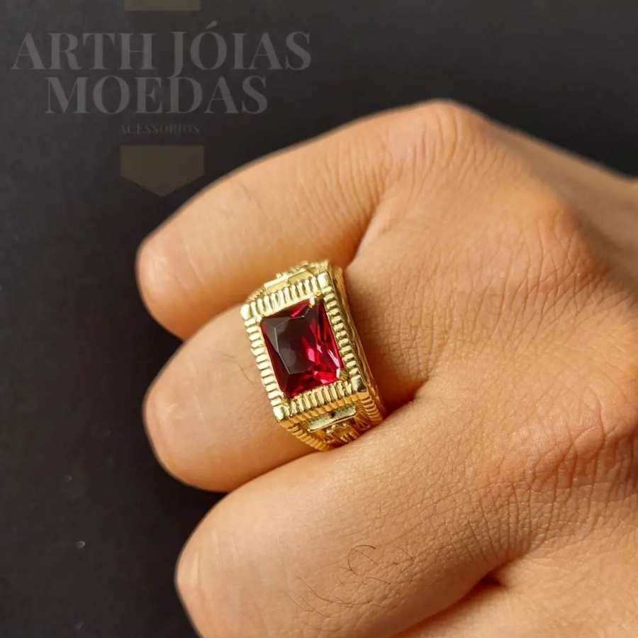 Homem de pele clara usando anel dourado com pedra vermelha