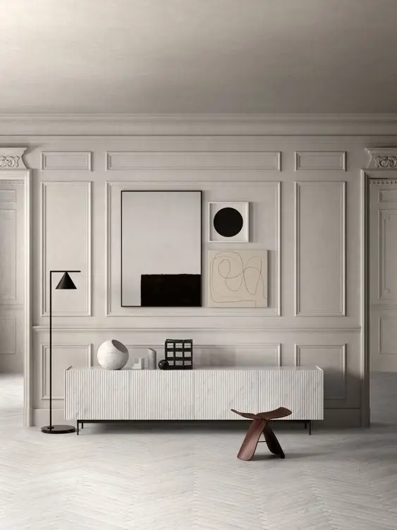 Hall de entrada em branco com aparador, itens decorativos, quados, luminária preta de pé e molduras 