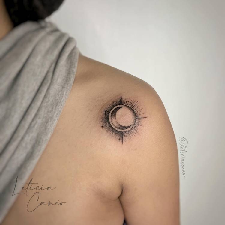 Mulher de pele clara com blusa cinza no pescoço e tatuagem de sol e lua, com sombras
