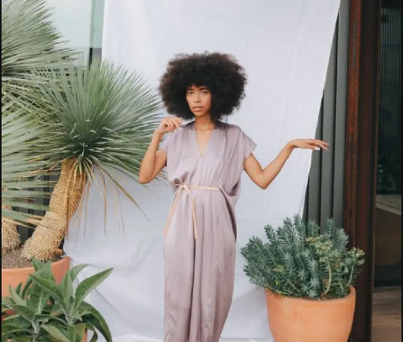 mulher em pé entre vasos de plantas