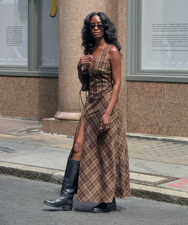 Mulher usando bota de cano alto, uma das tendências de sapatos para o inverno 2026