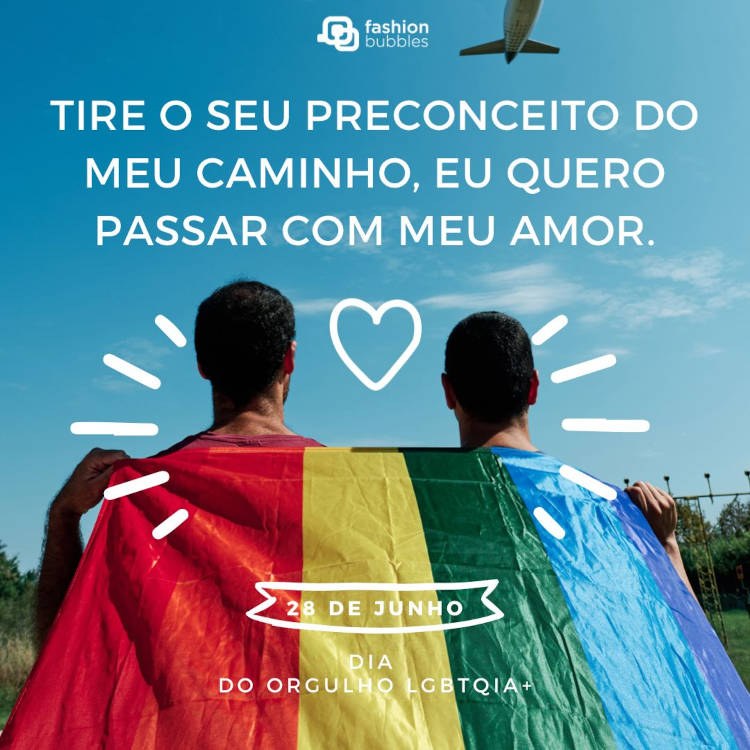 Foto de dois homens de costas carregando bandeira LGBT, com coração branco vazado e frase "Tire o seu preconceito do meu caminho, eu quero passar com meu amor."