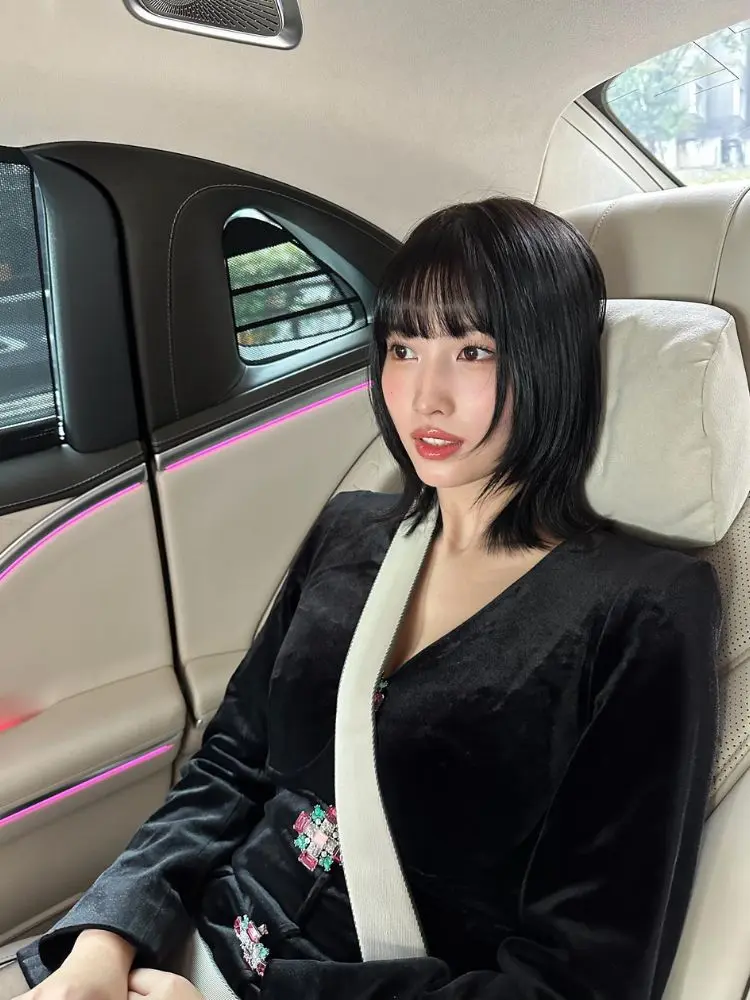 Momo com roupa preta no carro, com corte hime cut 