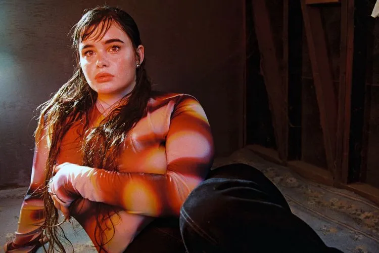 Barbie Ferreira em uma posição agachada com um a blusa de tule estampada