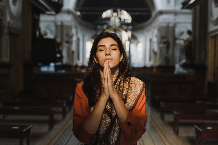Mulher de pele clara em igreja rezando