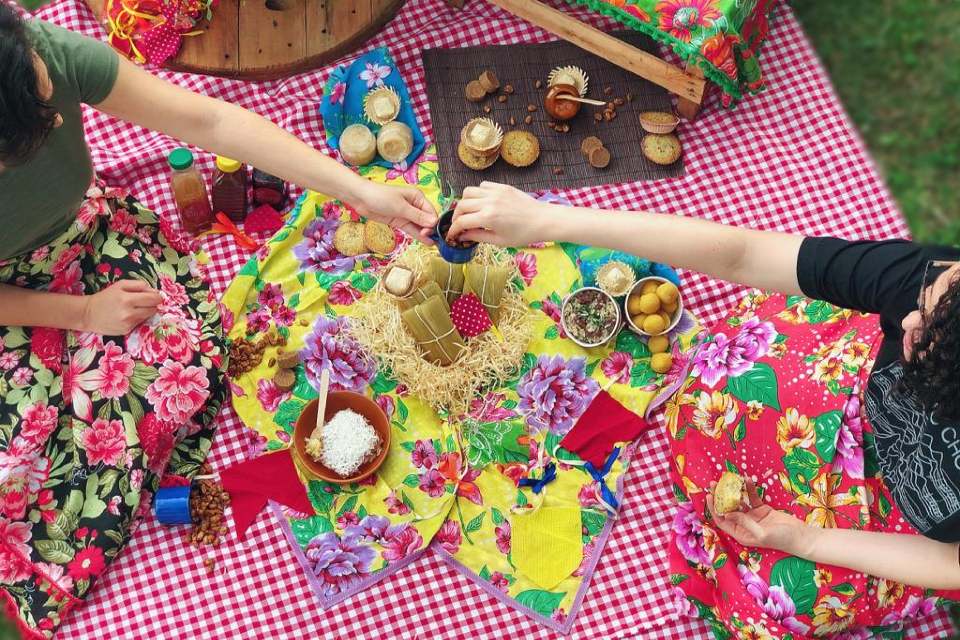Piquenique de festa junina com toalha xadrez vichy e comidinhas tradicionais de são joão como pamonhas