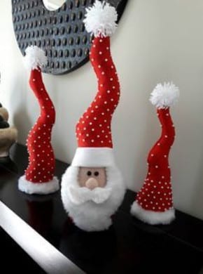 Foto de enfeite de papai Noel e gorros sobre aparador