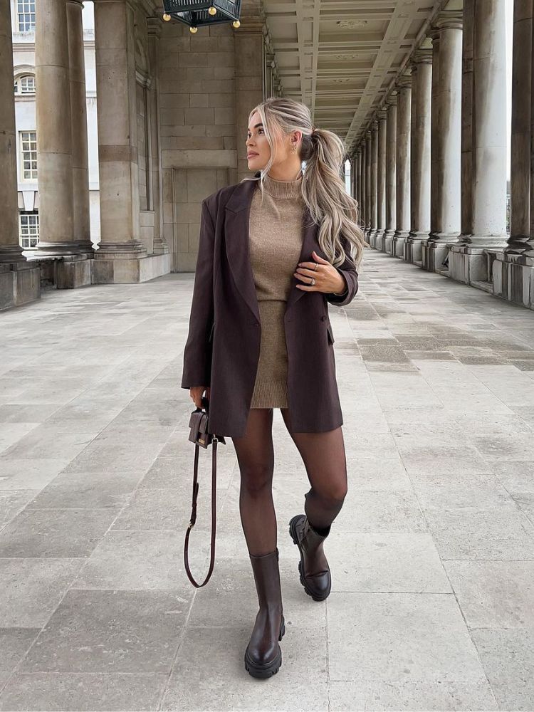 mulher usando vestido de lã camelo com blazer marrom, meia-calça e bota chelsea