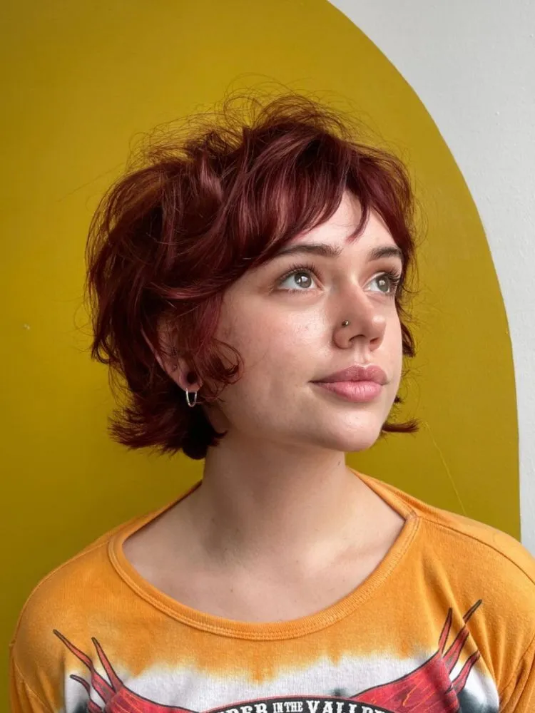 Mulher com cabelo vermelho curto e repicado