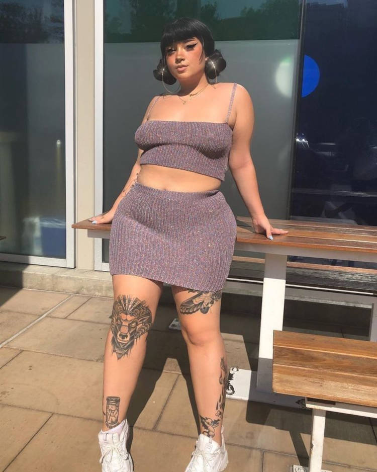 Mulher de pele clara com conjunto de cropped e saia curta de crochê roxo