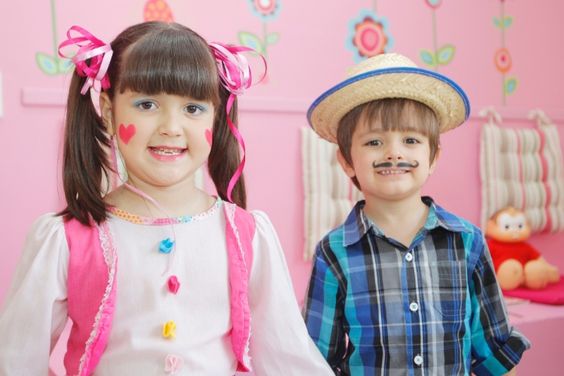 Menina e menino arrumados com trajes juninos e make