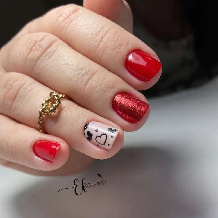 Nail art com a vermelho, glitter e adesivo de coração na filha única