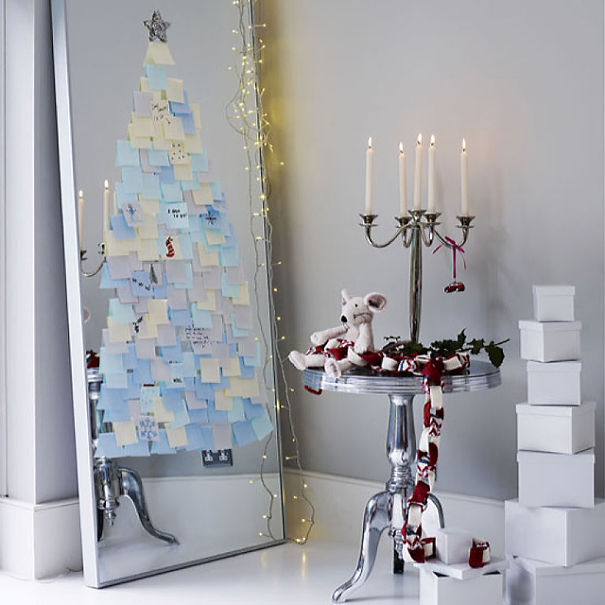 Espelho refletindo árvore-de-natal de parede feita de post-it