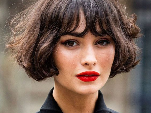 Mulher cabelo curto com franja e batom vermelho