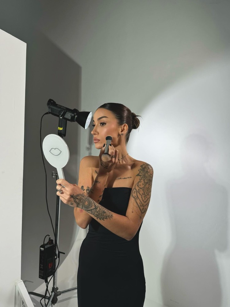 Bianca Andrade de roupa preta passando maquiagem no rosto 
