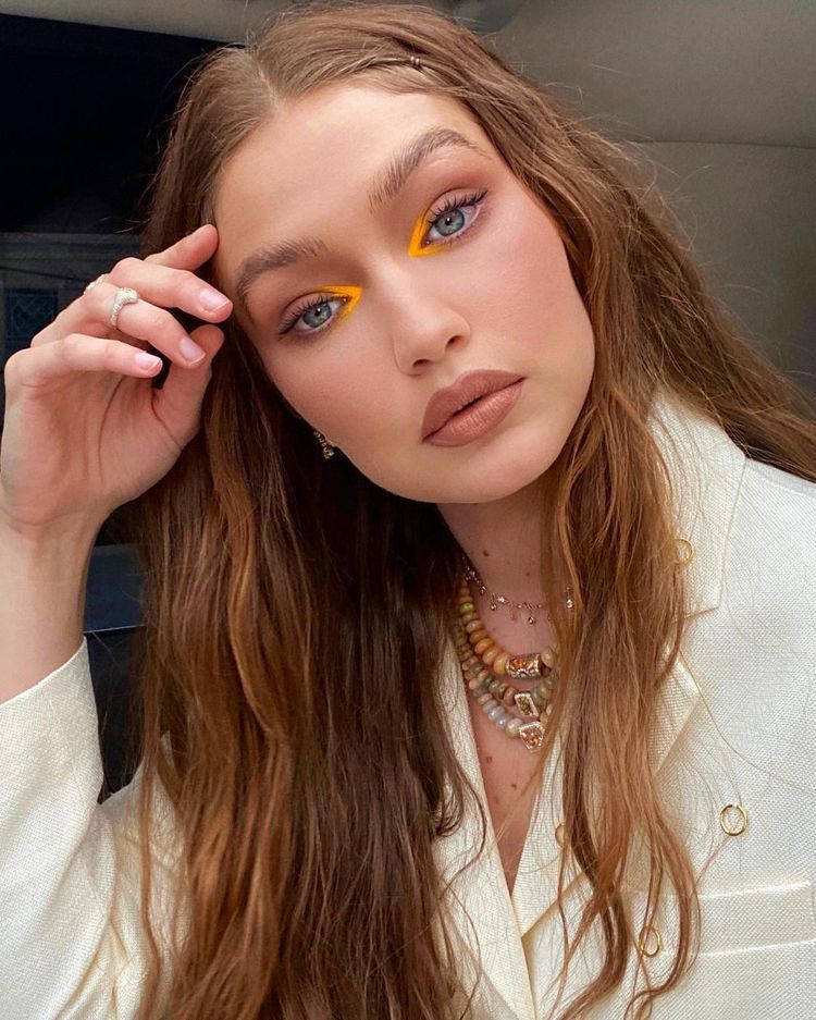 Gigi Hadid com batom nude e canto do olho com sombra amarela 
