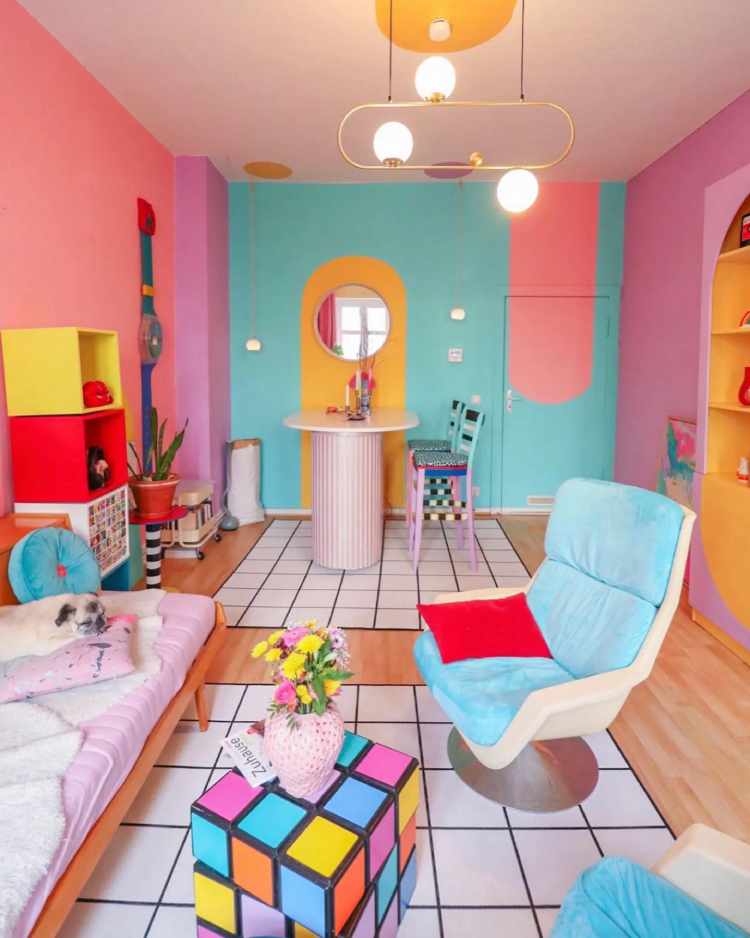 Sala com paredes coloridas, móveis coloridos, tapetes brancos e pretos e mesa de centro de cubo mágico com cores vibrantes