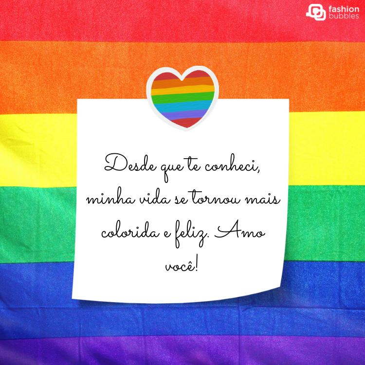 Cartão virtual com fundo nas cores do arco-íris, coração lgbt e post-it branco com frase "Desde que te conheci, minha vida se tornou mais colorida e feliz. Amo você!"