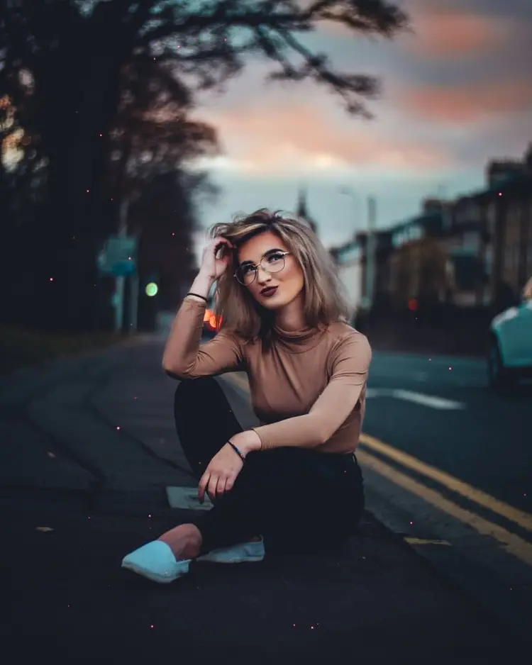 Frase para foto pensativa mulher loira sentada é usa óculos de grau e veste calça jeans preta, sapato branco e t-shirt mude