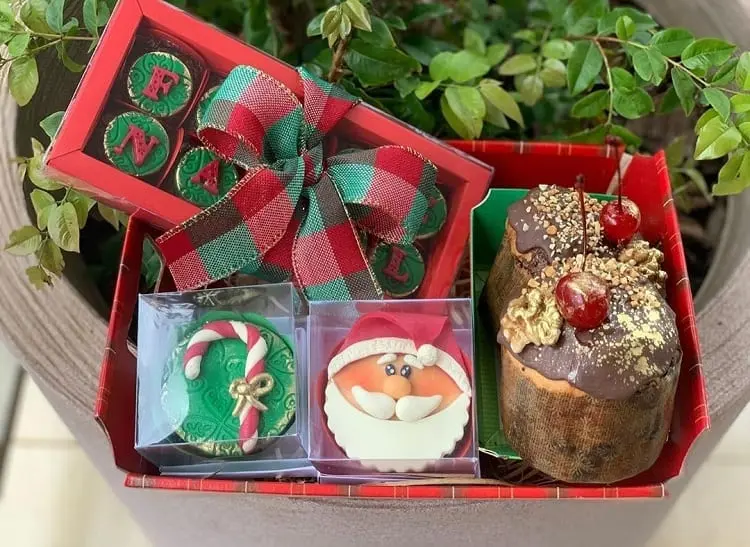 bombons, cupcakes e panetones decorados em caixa vermelha 