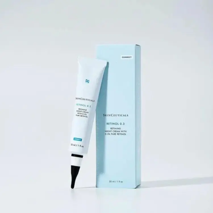 A imagem mostra um tubo e a caixa do SkinCeuticals Retinol 0.3, um creme noturno refinador com 0,3% de retinol puro. O tubo é branco com detalhes em azul e preto, e a caixa é azul-claro. Ambos indicam um volume de 30ml ou 1fl oz.

