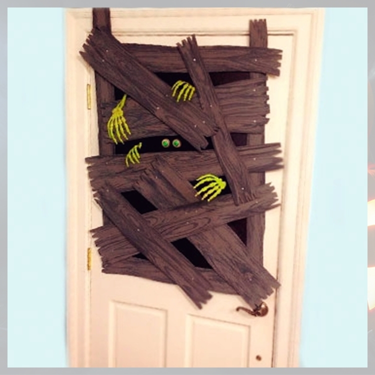 Foto de porta bege simulando monstros presos por pedaços de madeira pregados 