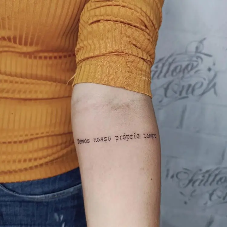 tatuagem escrita Temos nosso próprio tempo no braço