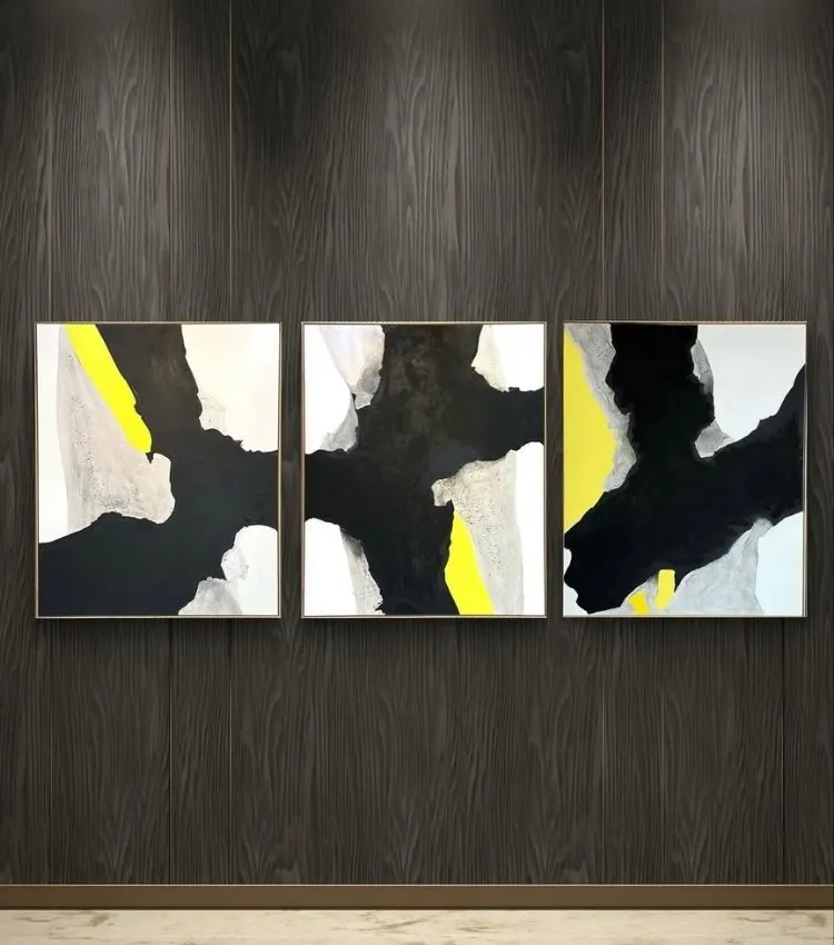 Parede decorada com quadro do artista plástico Adielson Rodrigues em tons de preto, cor tendência da decoração para 2026