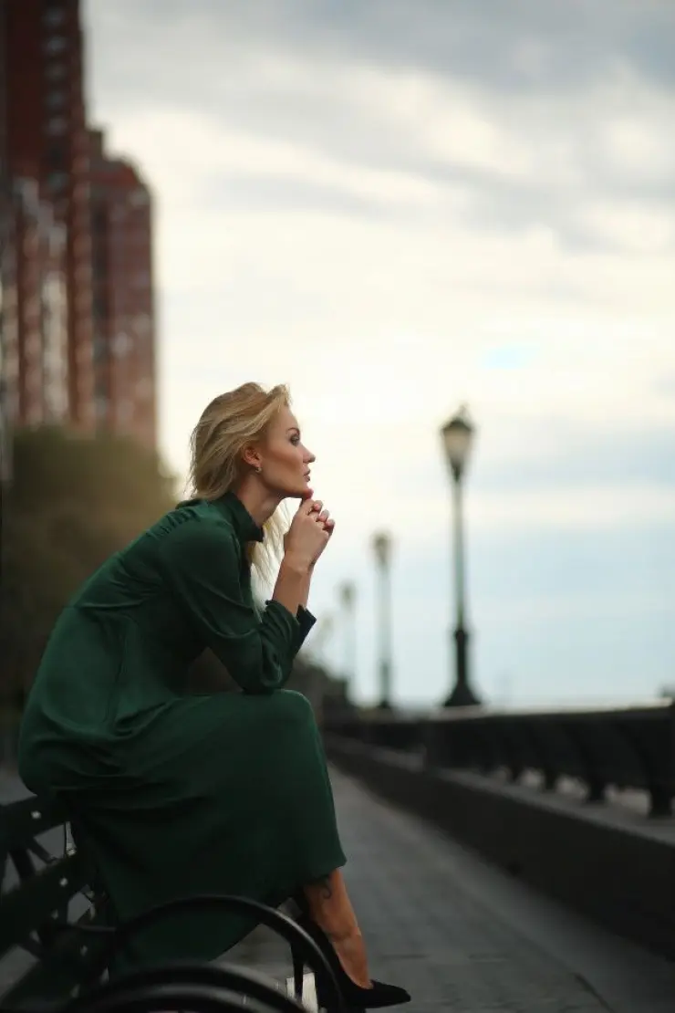 Frase para foto pensativa mulher branca sentada no banco usa vestido verde e scarpin preto Frase para foto pensativa