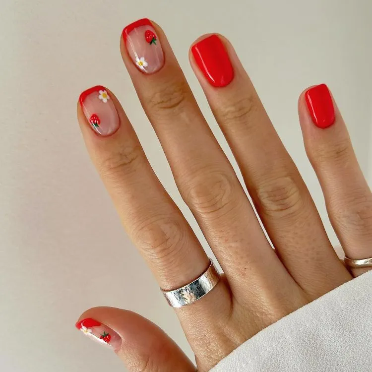 Unhas quadradas curtas, vermelhas, com nail art de morango 