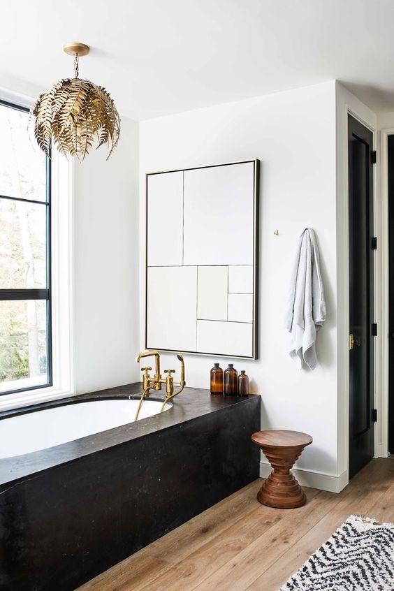 Banheiro com decoração de outono, com lustre de folhas e banheira com contorno preto