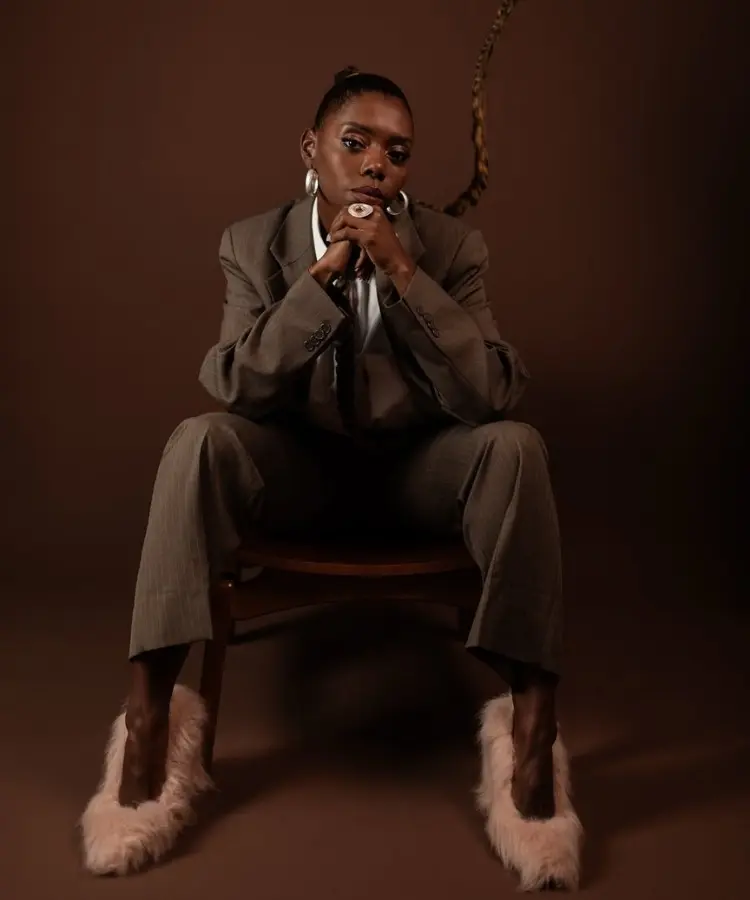Foto de Jacira Doce, uma das influenciadoras negras de moda, usando conjunto de alfaiataria e sapato de pelúcia